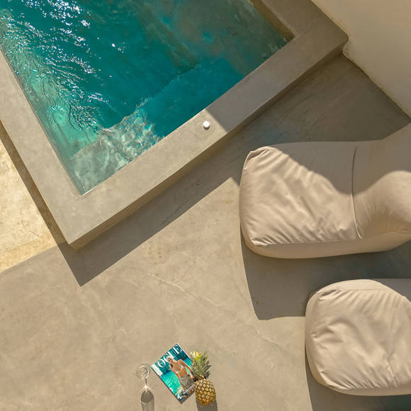 Nami Hotel Suites pool, sunbeds and a drink, a pineapple and a magazine in the middle